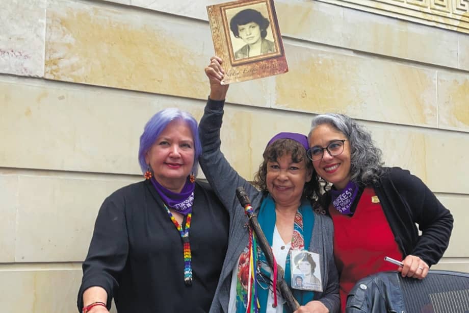 Yannette Bautista (centro), cabeza de la Fundación Nydia Érika Bautista, celebra la aprobación de la Ley de mujeres buscadoras con un bastón de mando indígena y la foto de su hermana, desaparecida en 1987. / Cortesía