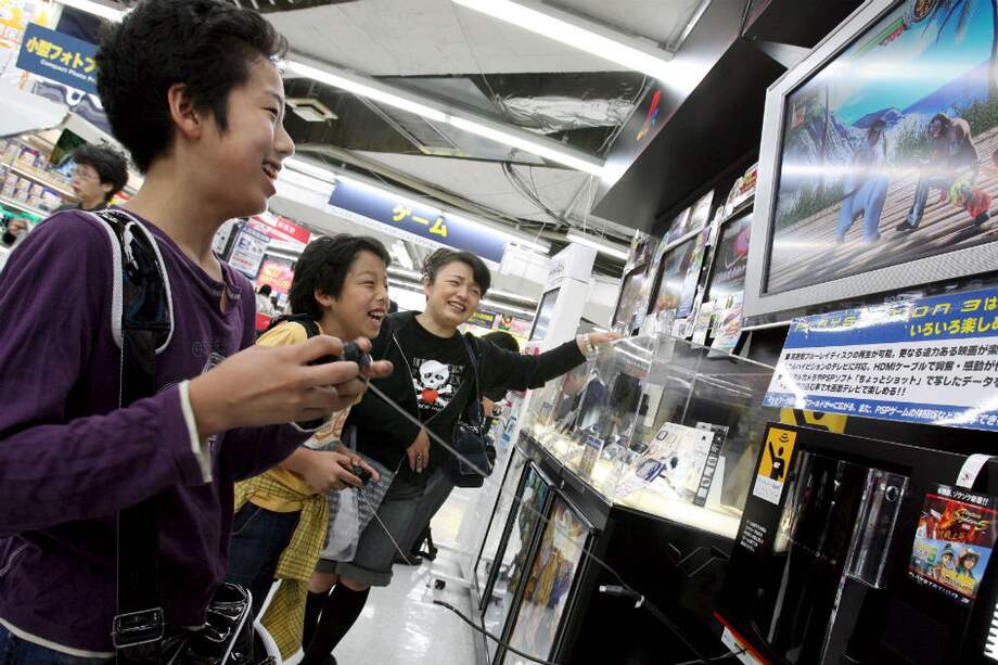 Dos niños japoneses juegan Play Station 3 en una tienda Sony de Tokio