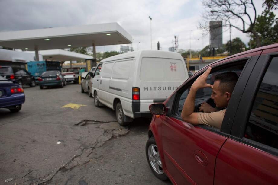 Las largas filas en Caracas son por baterías y ahora para conseguir tanquear los carros. La gasolina escasea. / AFP