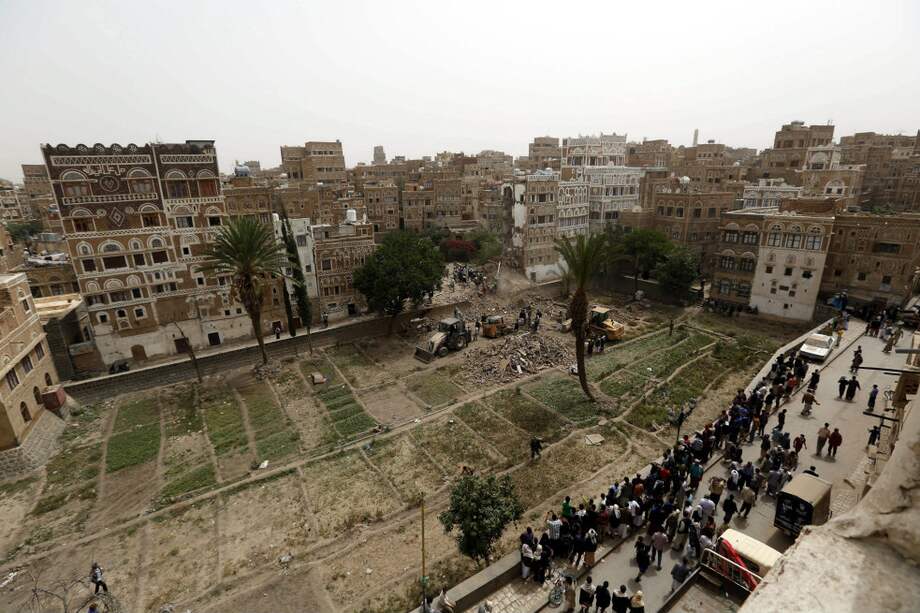 Varias personas inspeccionan los restos de varios edificios destrozados durante un supuesto bombardeo de la coalición árabe sobre el casco histórico de Saná, en Yemen. / Agencia EFE
