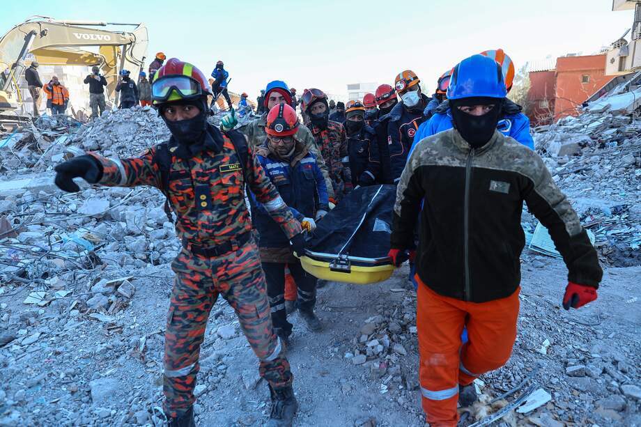 Rescatistas transportando un cuerpo encontrado en el lugar donde se derrumbaron varios edificios tras un fuerte terremoto, en Gaziantep.