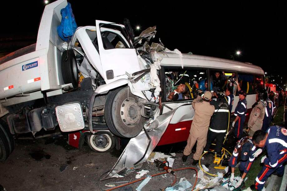 Fotografía cedida por A Crítica hoy que muestra a un grupo de socorristas en el lugar donde un microbús y un camión tuvieron un choque frontal, un accidente que dejó al menos 14 muertos y 19 heridos en la ciudad brasileña de Manaos, capital del estado de Amazonas (Brasil).
