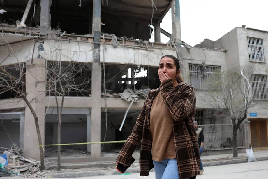 Una persona camina frente a un edificio impactado por un bombardeo en el norte de Teherán, capital de Irán.