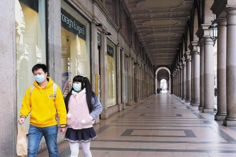 Dos turistas caminan por la semivacía calle Roma en Turín, una de las ciudades italianas en cuarentena. / EFE