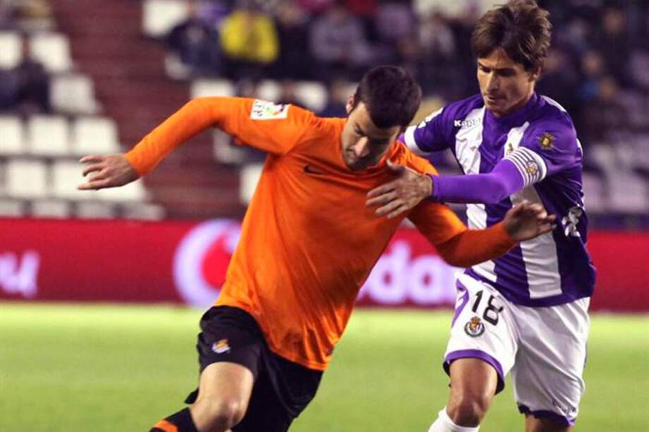 El delantero de la Real Sociedad, Imanol Agirretxe (i), se lleva el balón ante el acoso del defensor del Real Valladolid, Álvaro Rubio. / EFE