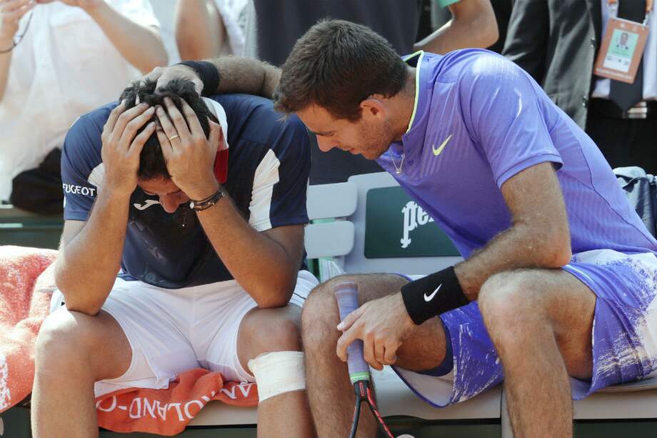 Nicolás Almagro es consolado por su compañero Juan Martín del Potro. / AFP
