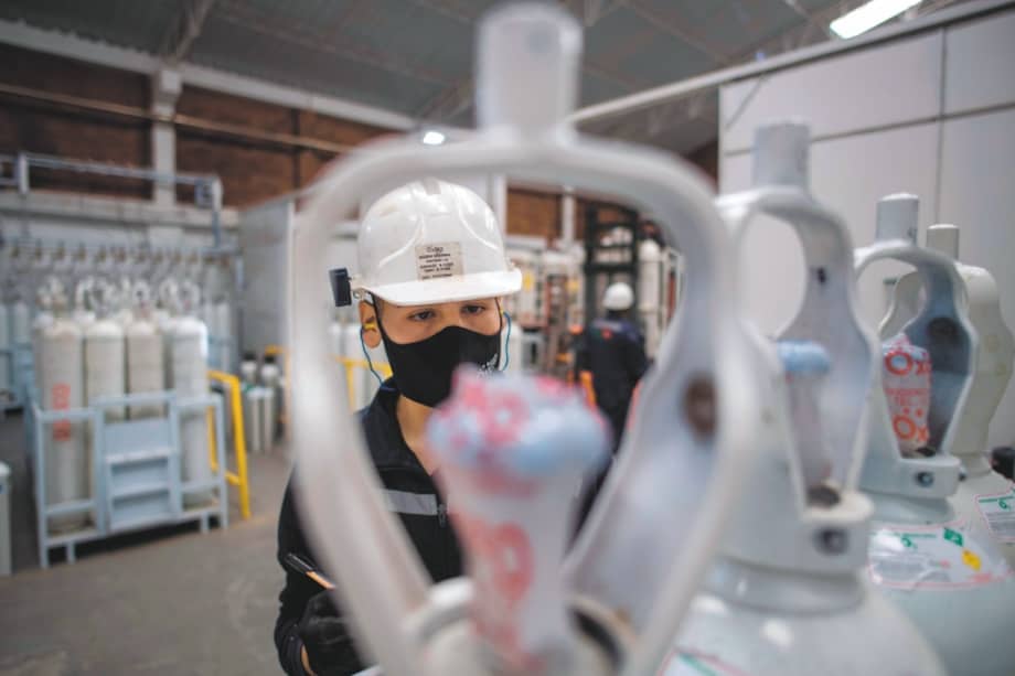 A worker checks oxygen cylinder to be used in intensive care units for COVID-19 patients in Bogota on January 29, 2021. / AFP / Juan BARRETO