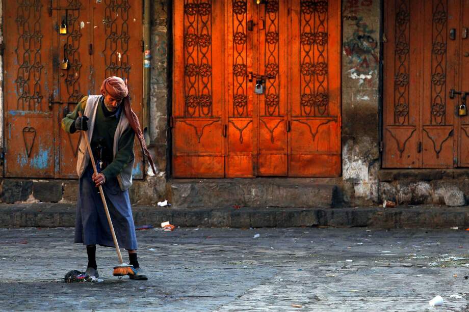 Un hombre limpia la calle en un mercado en la ciudad vieja de Saná (Yemen). / EFE