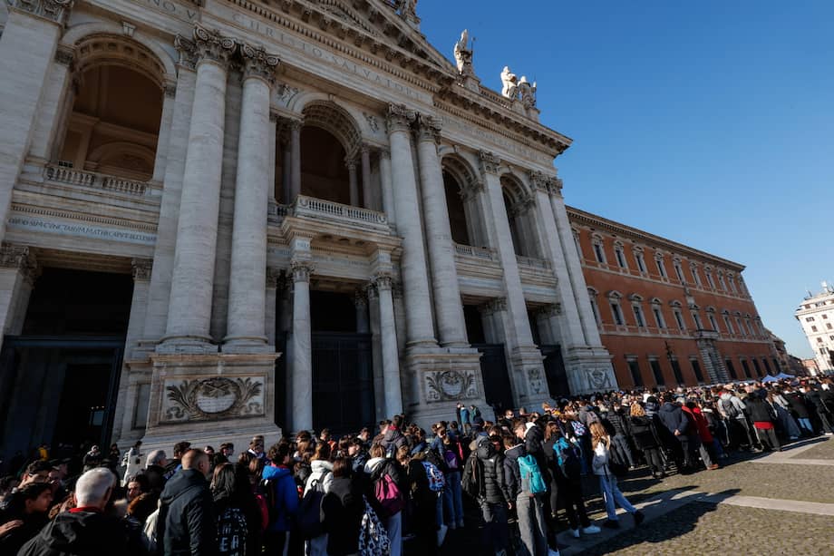Los peregrinos hacen fila para pasar ante la puerta santa de la Basílica de San Juan, en Roma, Italia.
