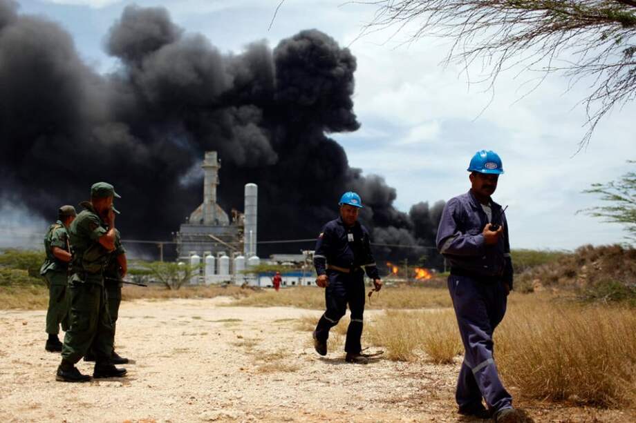 Guardia Nacional caminan cerca a una parte de la refinería de Amuay. Foto: EFE