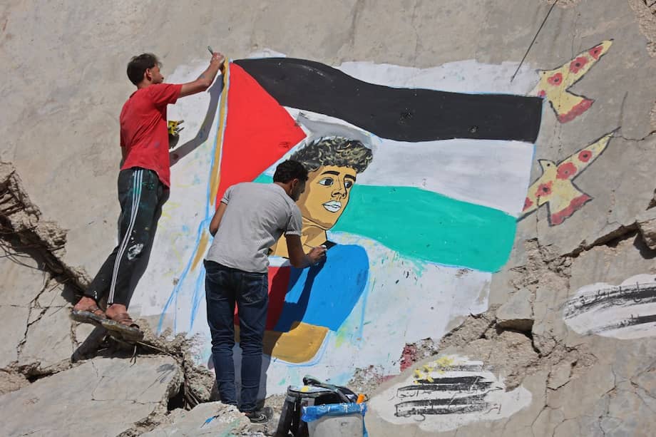 Artistas palestinos pintan un mural que muestra al futbolista Lamine Yamal ondeando una bandera palestina durante el desfile del título de los catalanes, sobre los escombros de edificios destruidos durante la guerra, en el campamento de refugiados de Shati (Beach), en la ciudad de Gaza, el 13 de mayo de 2026.
