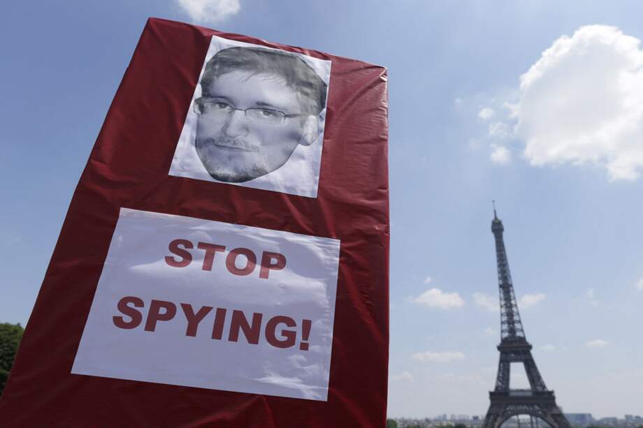 Los manifestantes sostienen un cartel con una foto de Edward Snowden, un ex contratista técnico de la Agencia Central de Inteligencia de EE.UU., durante una manifestación en apoyo de Snowden en la Place du Trocadero en frente de la torre Eiffel en París. /AFP