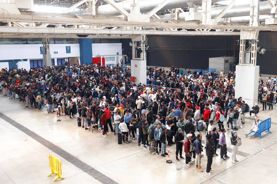 Centenares de personas migrantes hacen cola desde primera hora en el recinto ferial La Farga de L'Hospitalet de Llobregat, en Barcelona, para conseguir los documentos que faciliten su regularización en España.