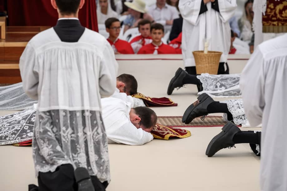 Sacerdotes y diáconos se postran durante una ceremonia de ordenación de la tradicionalista Sociedad Católica de San Pío X.