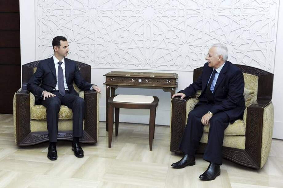 el presidente sirio, Bachar al Asad (i), durante la ceremonia de juramento del nuevo Presidente del Consejo de Estado, Mohamed Yousef al-Hussein (d), en Damasco, Siria.