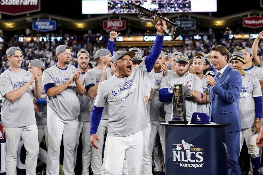 El entrenador de los Dodgers, Dave Roberts (C), sostiene el trofeo después de que su equipo ganara el sexto partido de la Serie de Campeonato de la Liga Nacional de Béisbol de las Grandes Ligas (MLB).