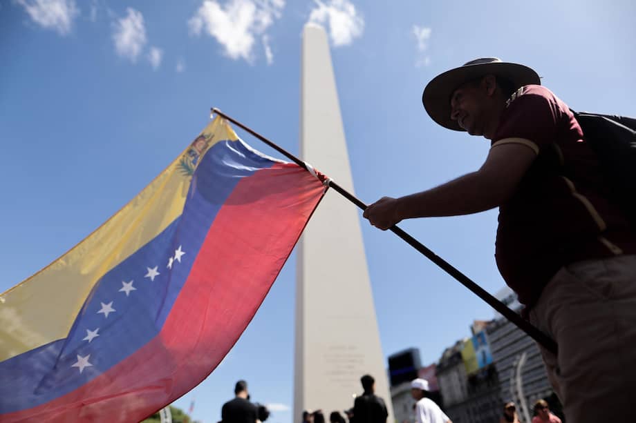 Un ciudadano venezolano ondea una bandera de su país durante una manifestación en apoyo a la intervención de Estados Unidos en Venezuela frente al obelisco en Buenos Aires (Argentina).