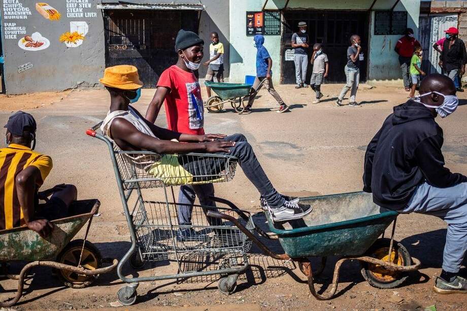 Mensajeros se sientan en sus carretillas esperando llevar comida de una escuela a sus clientes en el barrio de chabolas cercano el día 40 del cierre nacional como resultado de COVID-19 Coronavirus en Johannesburgo, Sudáfrica. / efe