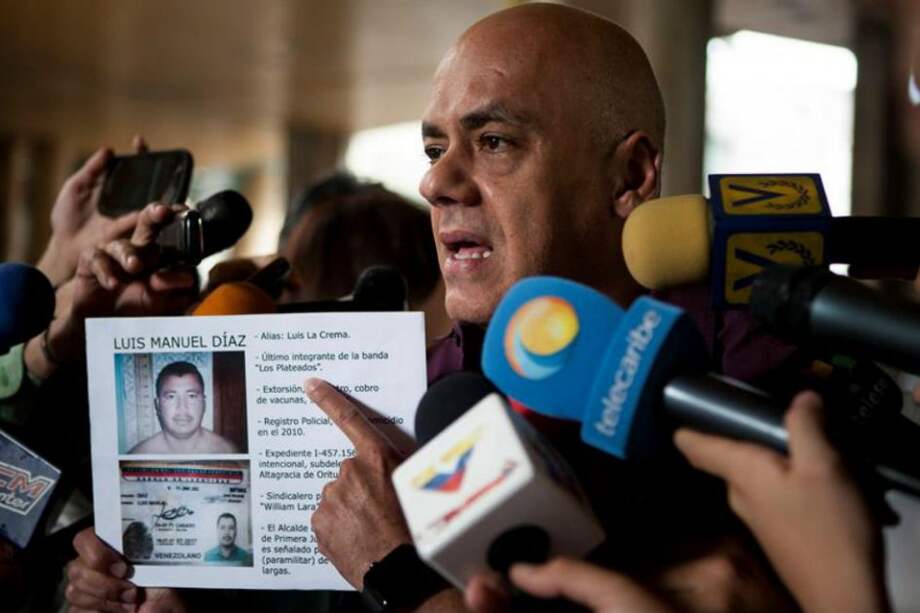 El jefe de campaña del chavismo, Jorge Rodríguez muestra la imagen del opositor asesinado y lo acusa de hacer parte de una banda criminal y dice que era investigado por homicidio. / EFE