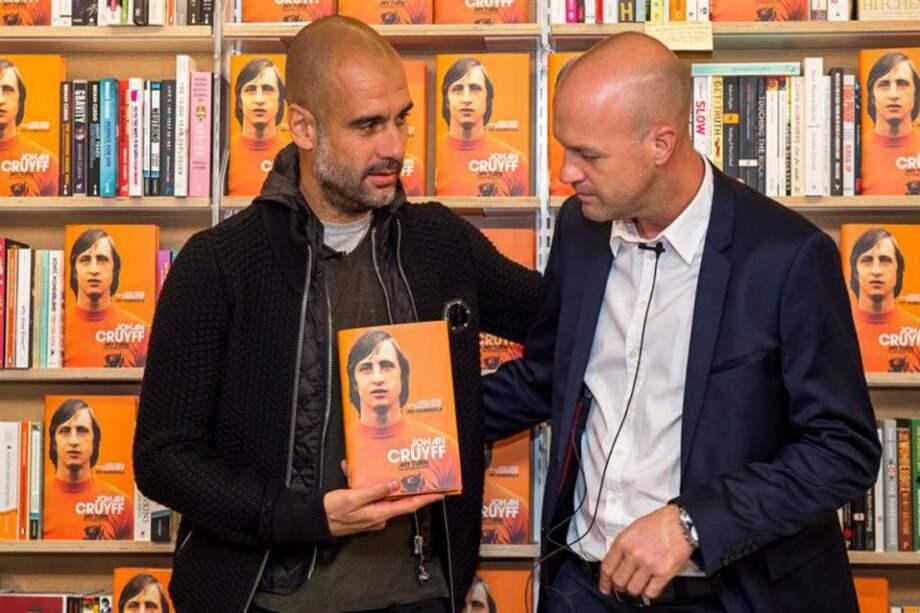 El entrenador español del Manchester City, Pep Guardiola (i), y el exfutbolista holandés Jordi Cruyff (d) posan con un ejemplar durante la presentación de la biografía de Johan Cruyff, "14. La autobiografía" en una librería del centro de Londres, Reino Unido, este jueves. / EFE