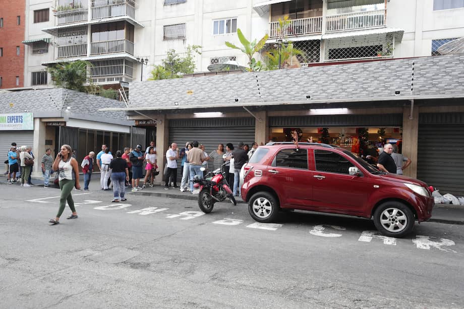 Personas hacen fila en un supermercado para abastecerse este sábado en Caracas (Venezuela).