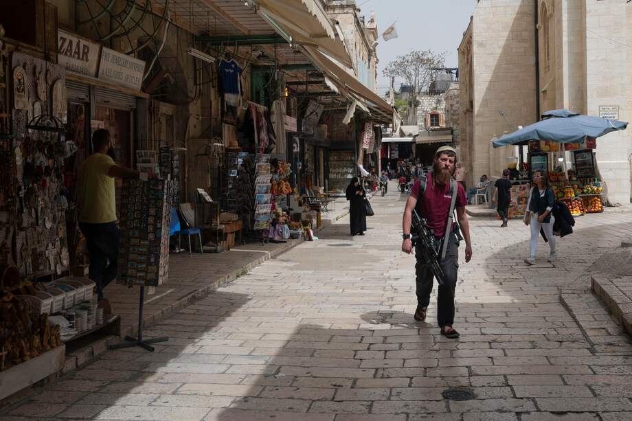 Un hombre armado camina por la Ciudad Vieja.