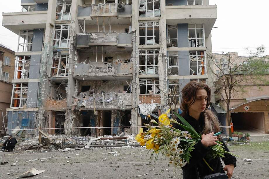 Una mujer pasa junto a un edificio alcanzado por un ataque, tras el lanzamiento de drones y misiles desde Rusia.