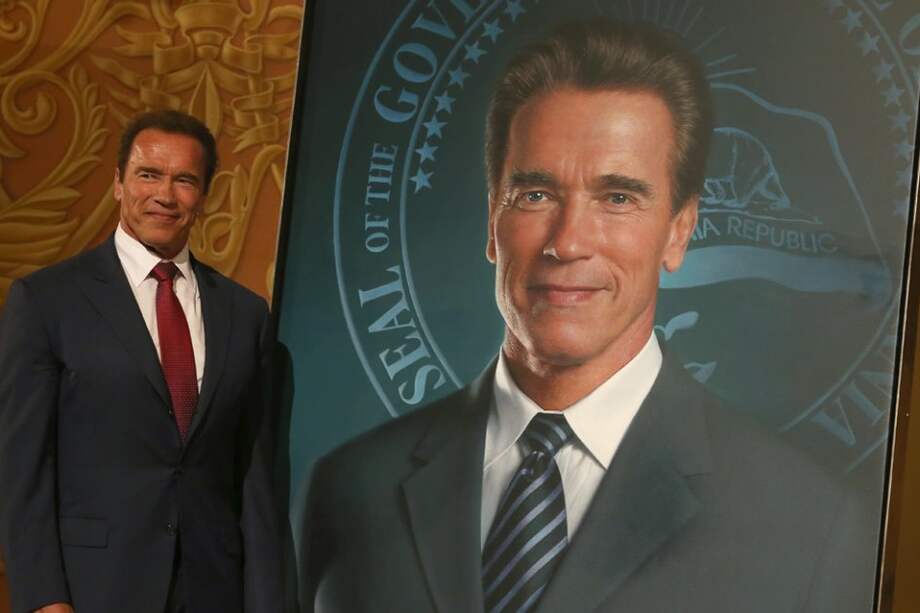 Arnold Schwarzenegger posa junto a su retrato.
