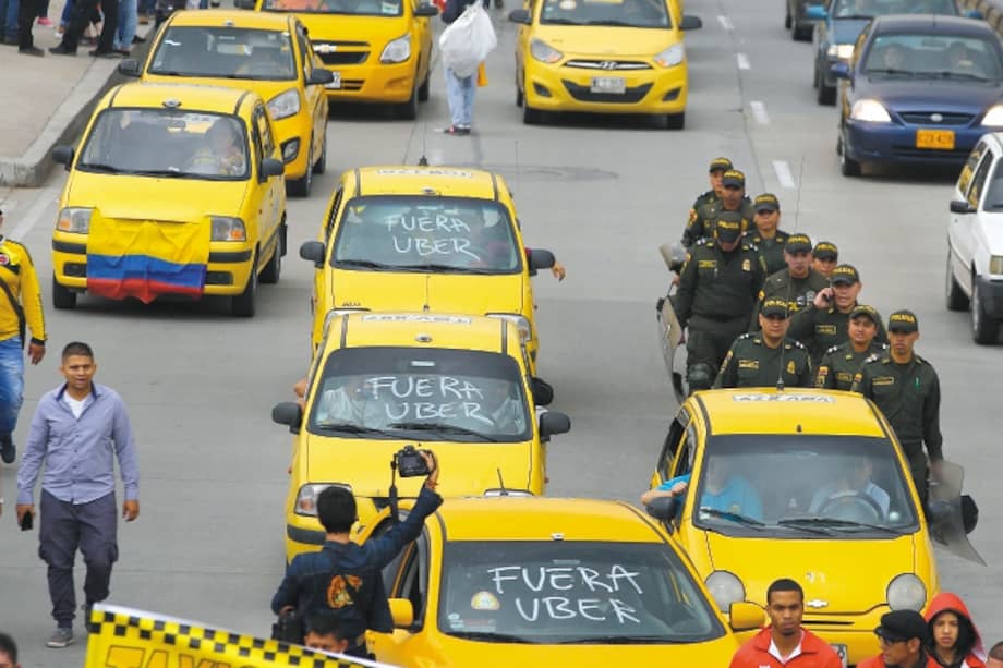 Taxi drivers march as they strike to pressure the government to ban the ride-sharing app Uber, in Bogota, Colombia, Wednesday, May 10, 2017. Hundreds of taxi drivers from different cities in Colombia began a strike on Wednesday, denouncing Uber as a "pirate" taxi service that does not meet the requirements required by law. (AP Photo/Fernando Vergara)