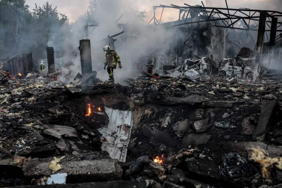 Miembros de los servicios de rescate ucranianos trabajan entre los escombros de un edificio tras el ataque con misiles contra una zona residencial de Kiev (Ucrania) este martes.