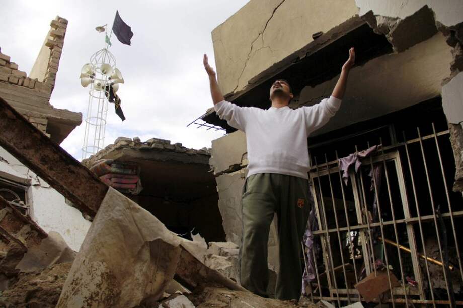 Un iraquí se lamenta mientras permanece entre los escombros de su hogar tras la explosión de un carro bomba en el sur de Bagdad, Irak/ EFE