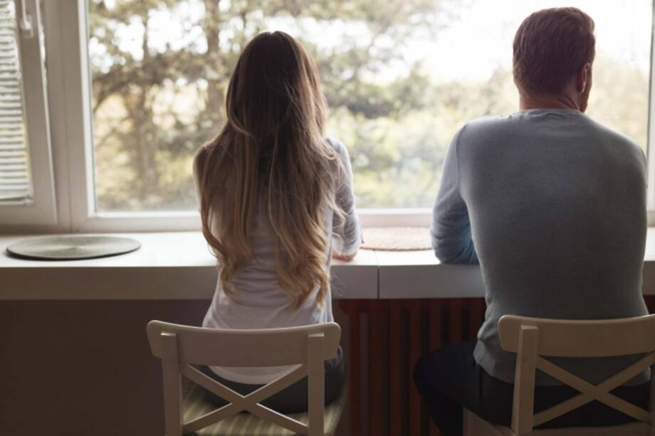 Pareja mirando hacia la a ventana