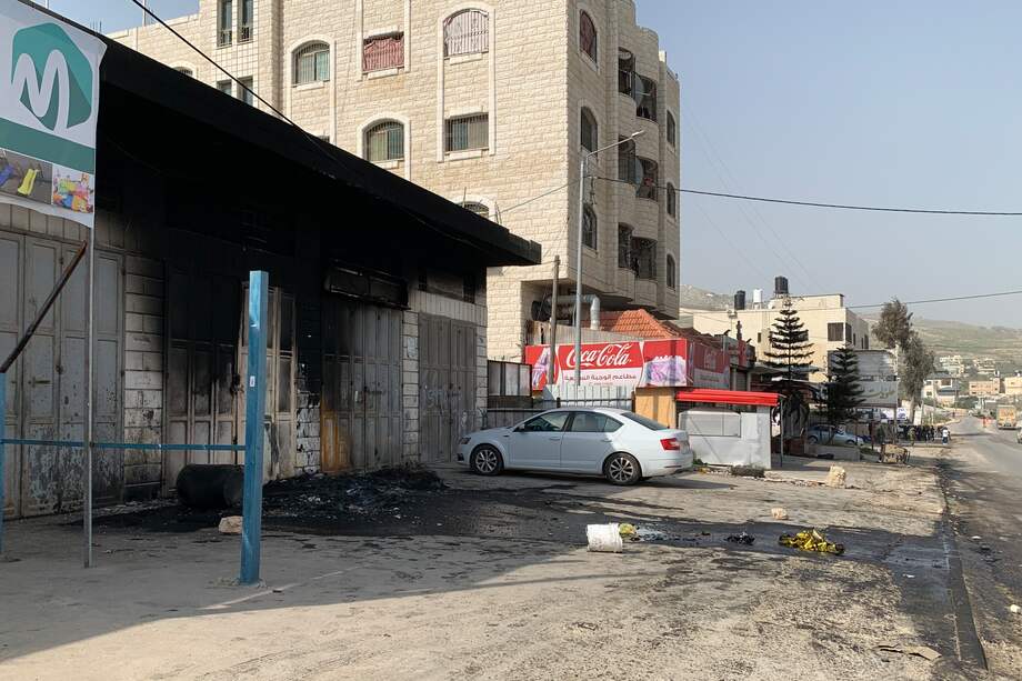 Vista de edificios, coches y negocios palestinos calcinados en el pueblo palestino de Huwara (Cisjordania) este lunes tras el asalto anoche de unos 400 colonos en venganza por un ataque palestino que mató a dos israelíes horas antes a pocos metros de allí.