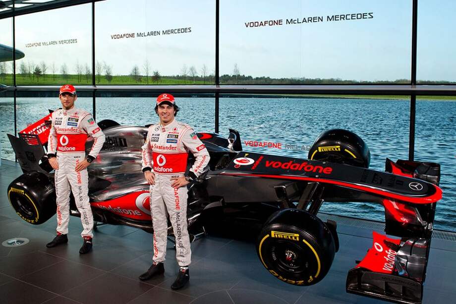 Jenson Button (i) y Sergio Pérez, junto a su nuevo monoplaza, el MP4-28.