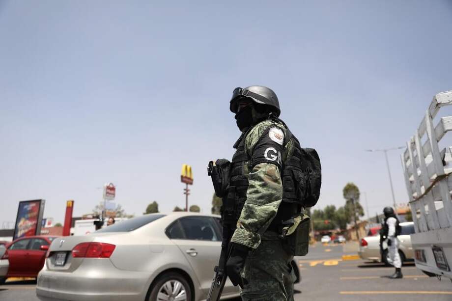Un integrante de la Guardia Nacional vigilando afuera de un centro comercial para evitar saqueos en el municipio de Ojo de Agua, México. / EFE