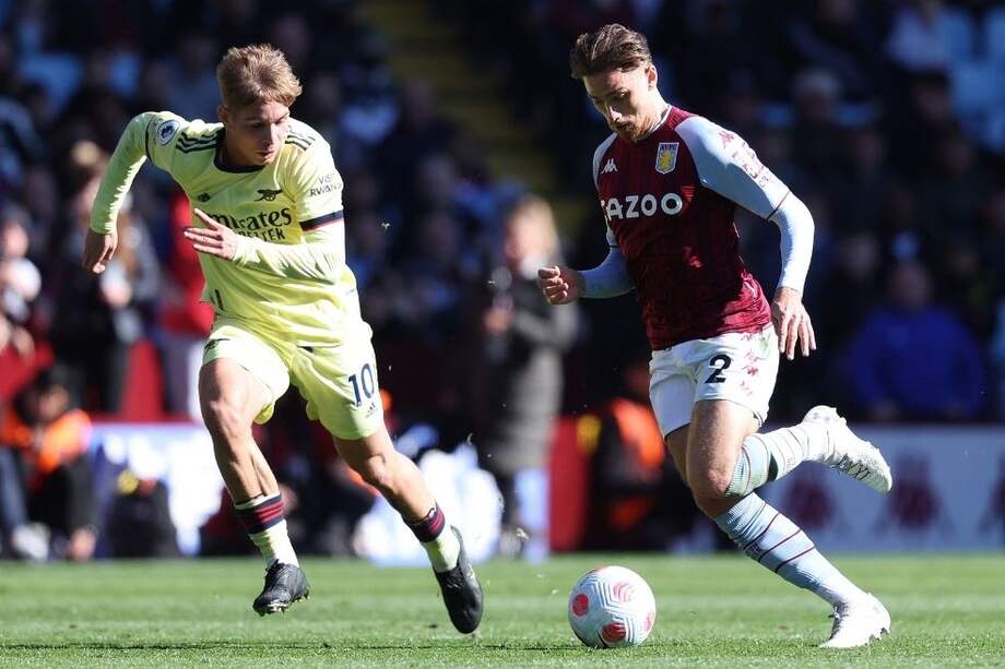Matty Cash (derecha), disputa el balón con el mediocampista de Arsenal, Emile Smith.