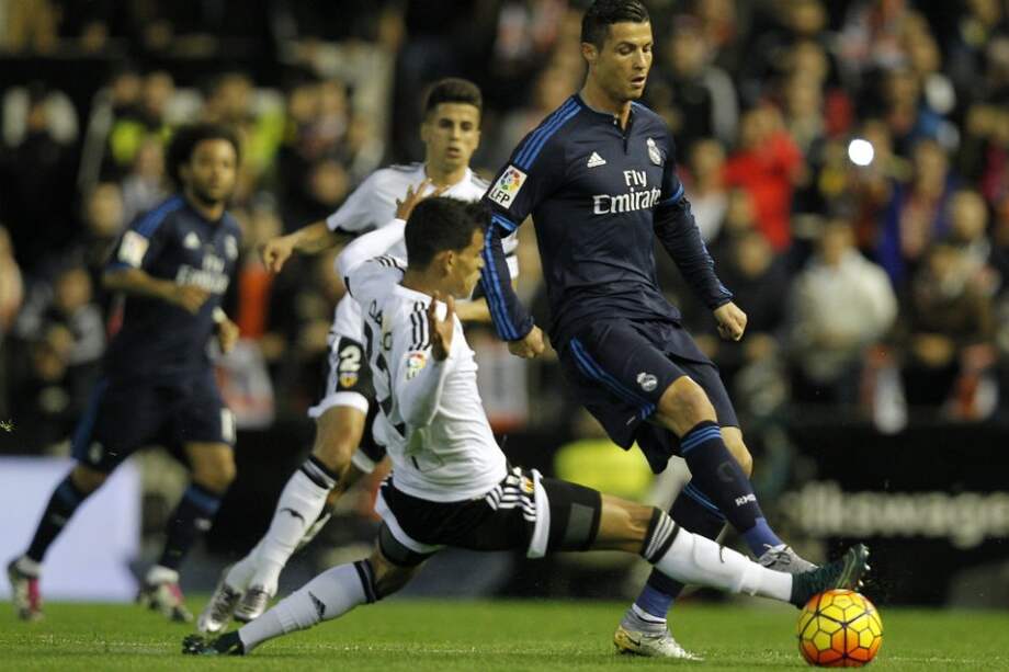 El jugador Danilo Barbosa (i) del Valencia disputa una pelota con Cristiano Ronaldo del Real Madrid. / AFP