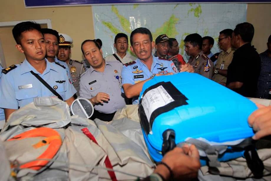 Militares muestran una maleta localizada en alta mar y que, se cree, pertenece a uno de los pasajeros del avión desaparecido de AirAsia cuyos restos han sido localizados en alta mar.