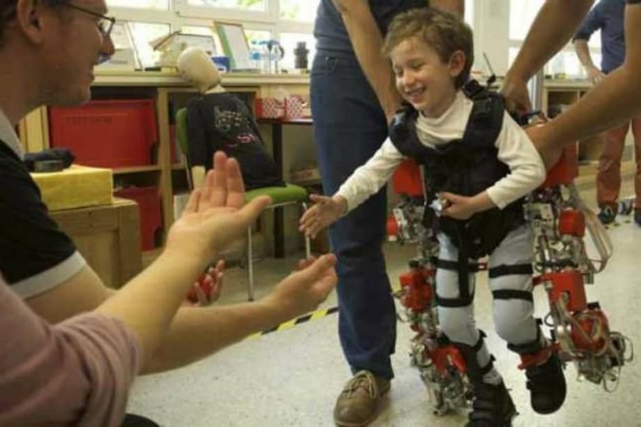 Álvaro, de cinco años y afectado por atrofia muscular espinal, camina hacia sus padres durante una prueba del exoesqueleto. / Joan Costa – CSIC - SINC