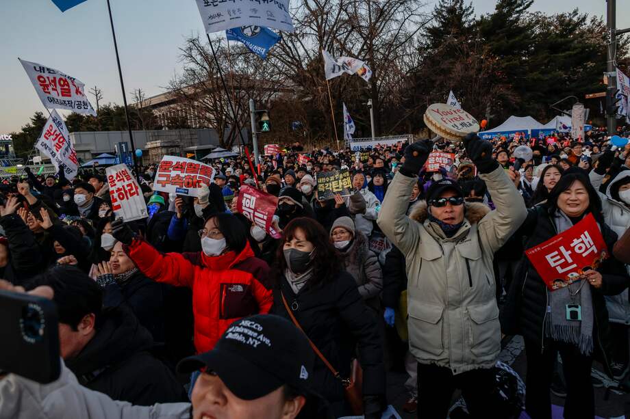 Manifestantes celebran la aprobación de una moción de destitución contra el presidente Yoon Suk Yeol durante una manifestación frente a la Asamblea Nacional en Seúl, Corea del Sur, el 14 de diciembre de 2024.