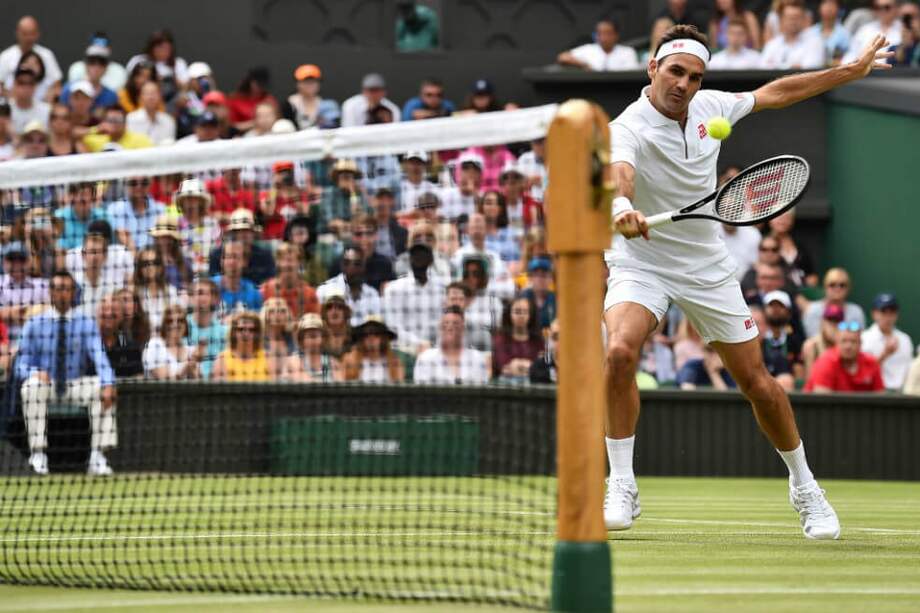 Federer responde una pelota durante su partido de tercera ronda de Wimbledon. / AFP