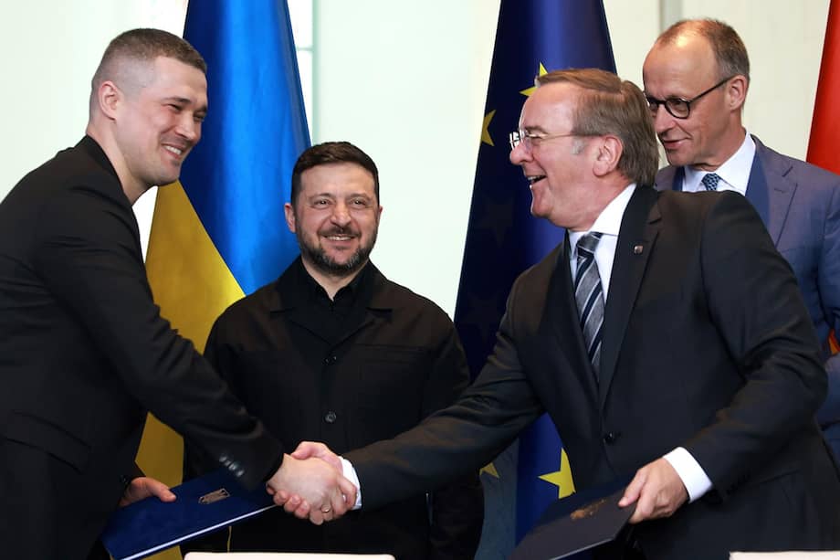 El ministro de Defensa alemán, Boris Pistorius (de corbata gris al frente), saluda a su homólogo ucraniano, Mykhailo Fedorov (de traje negro), y al presidente ucraniano, Volodimir Zelenski, durante su visita a Berlín en abril. Les acompaña el canciller, Friedrich Merz.