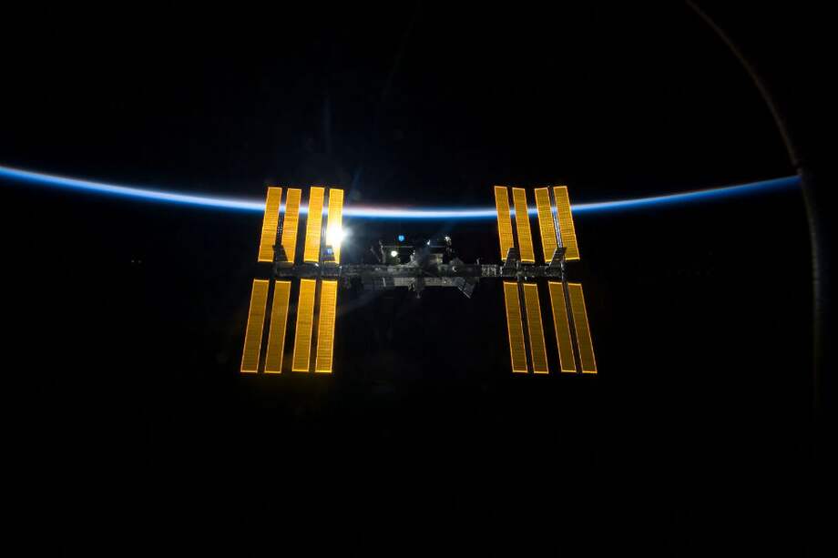 La Estación Espacial Internacional en contraste a la negrura del espacio y la delgada línea de la atmósfera de la Tierra. Imagen tomada desde el Transbordador Espacial Discovery antes de que las dos naves espaciales iniciasen su separación. / NASA