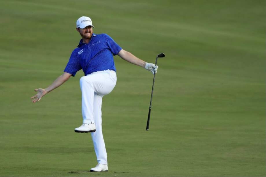 El estadounidense Jimmy Walker reacciona a su tercer impacto en el hoyo 18, durante la primera ronda del Torneo de Campeones. / AFP