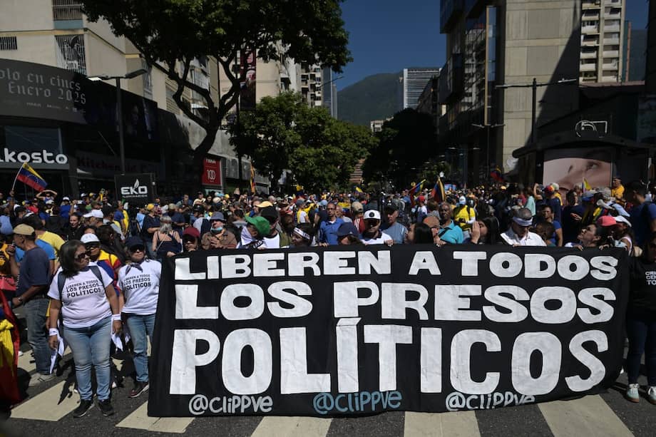 Manifestantes sostienen una pancarta exigiendo la liberación de todos los presos políticos durante una protesta convocada por la oposición en vísperas de la toma de posesión presidencial, en Caracas.