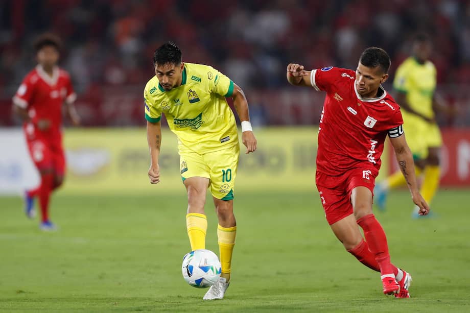 Rafael Carrascal de América de Cali disputa el balón con Fabián Sambueza de Atlético Bucaramanga durante el partido de la primera fase de la Copa Sudamericana en el estadio Pascual Guerrero de Cali, Colombia.