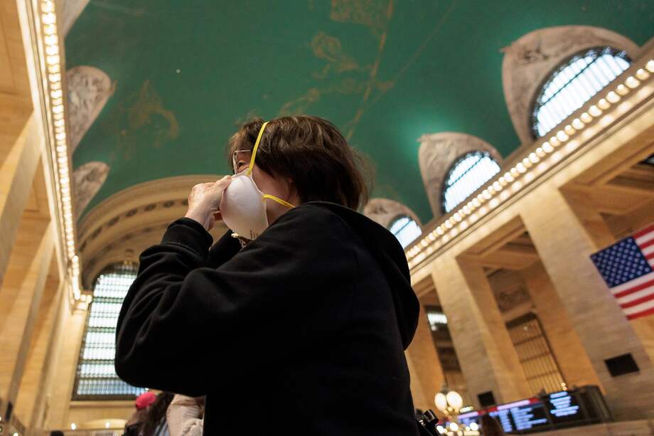 Una mujer ajusta su mascarilla en el terminal de Nueva York, ciudad que se ha visto inundada por el humo de los incendios forestales que azotan a Canadá.