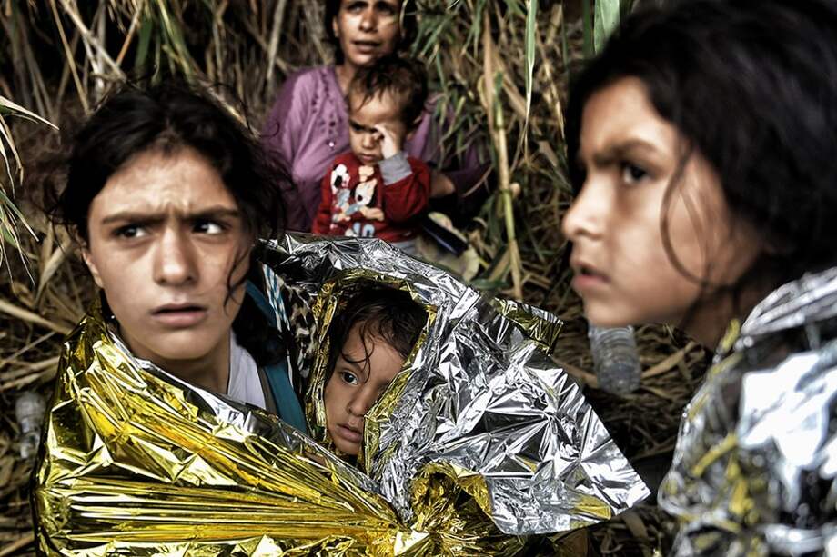 Mujeres sirias llegan a la isla girega de Lesbos, deben ser cubiertas con con mantas térmicas que eviten la hiportermia. / AFP