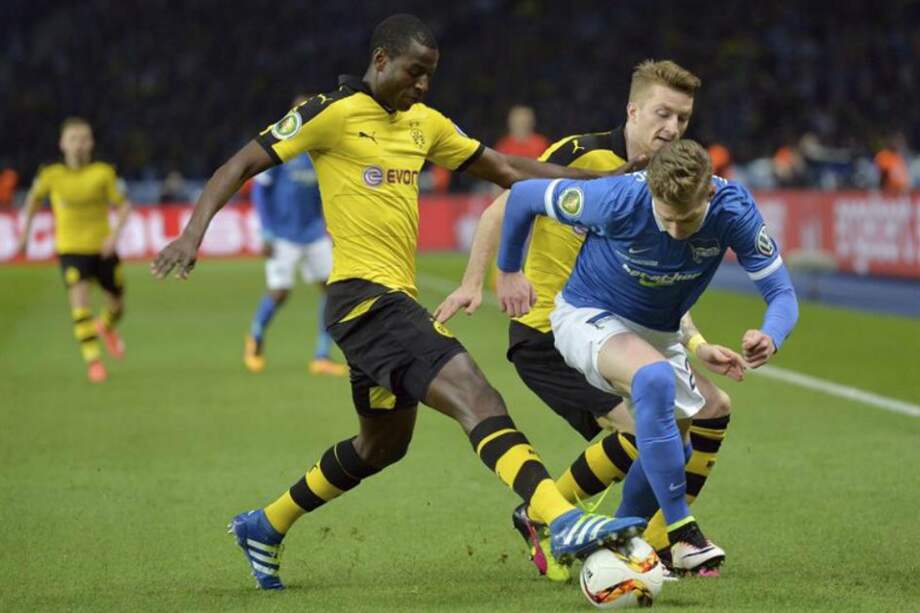 El centrocampista del Hertha BSC Mitchell Weiser (d) lucha por el balón con Adrian Ramos (i) y Marco Reus (detrás). / EFE
