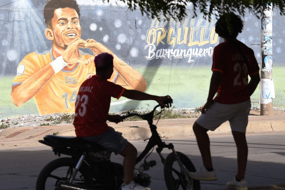 Los fanáticos de la estrella del fútbol inglés del Liverpool, el colombiano Luis Díaz, miran un mural que lo representa, en Barrancas.